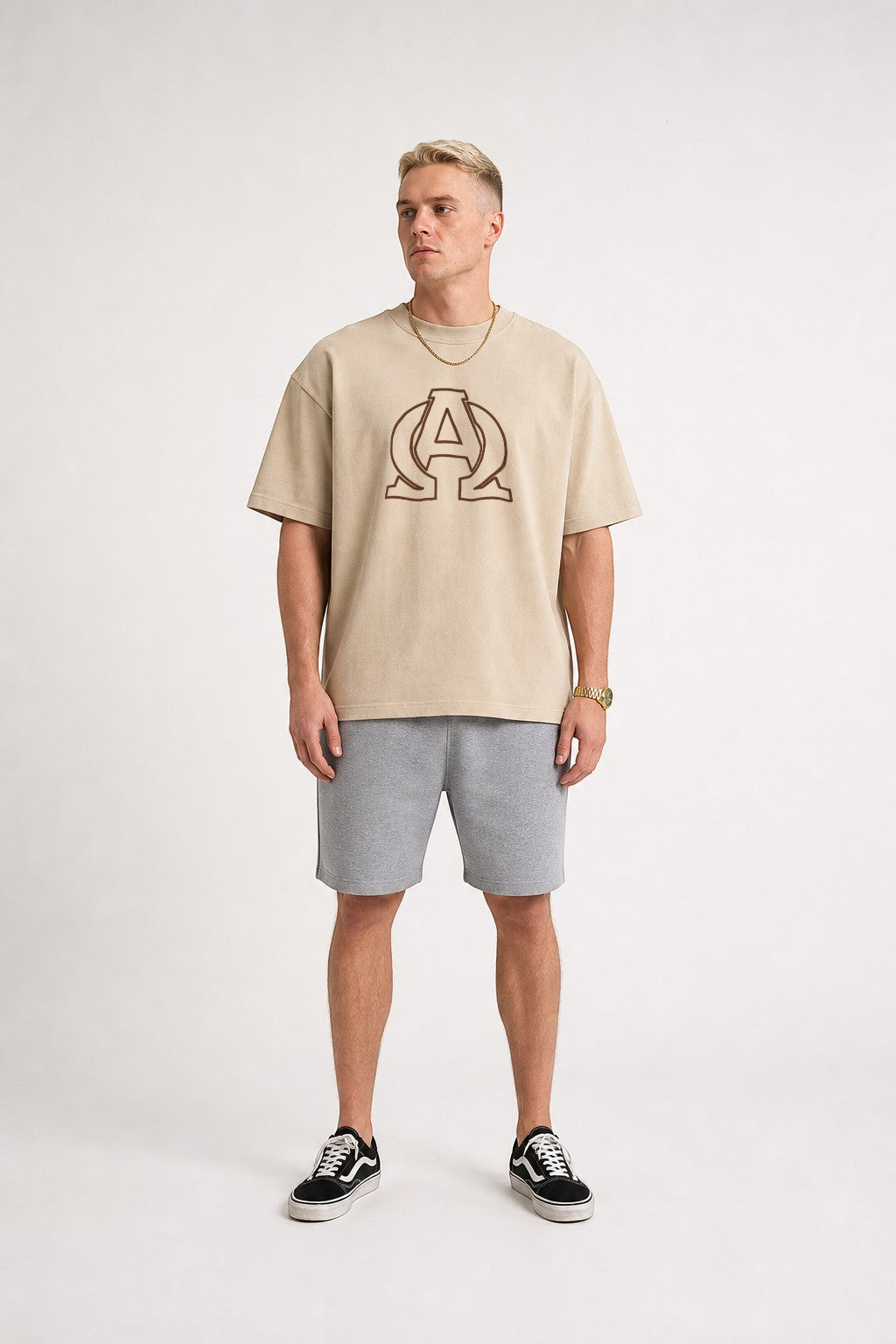 Reyes & Company oversized beige Christian t-shirt with brown Alpha and Omega logo worn by a male model.